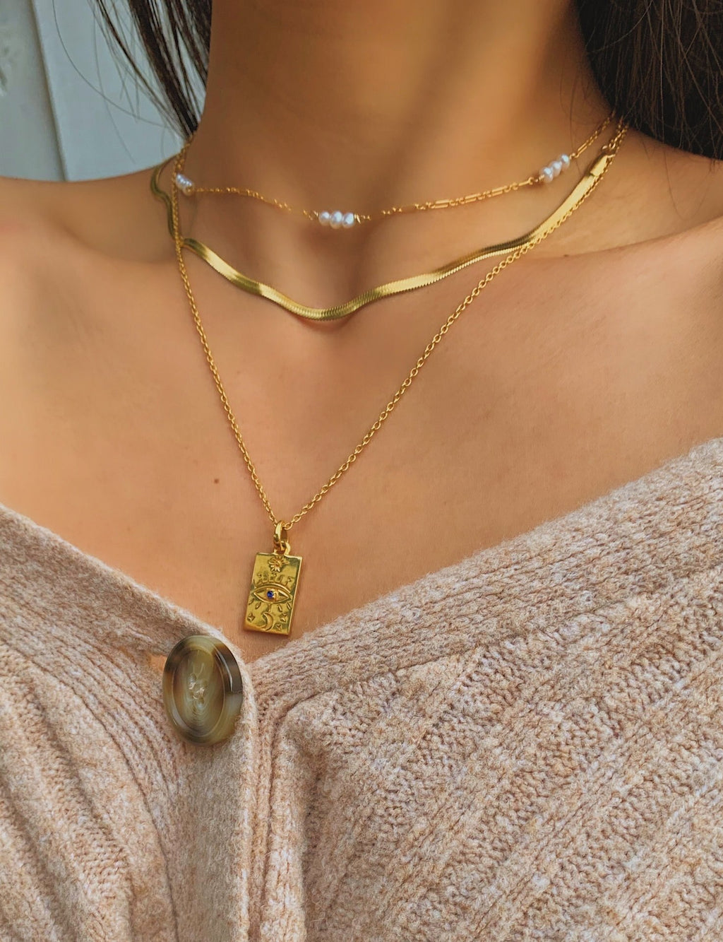 Collier pendentif doré à motifs symboliques