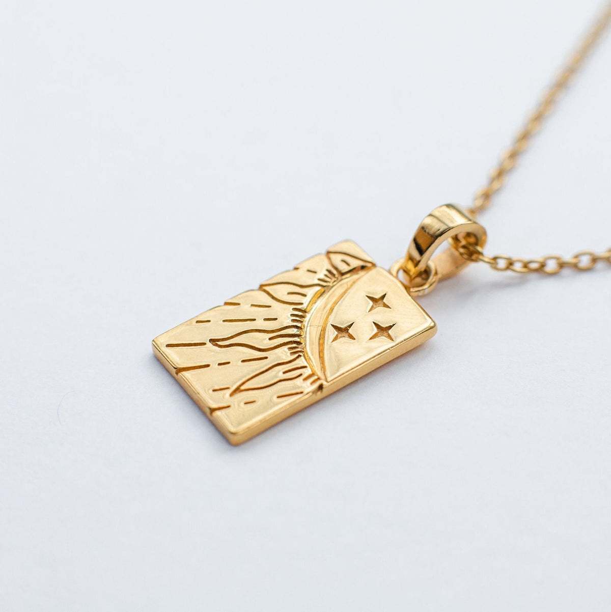 Collier pendentif doré à motifs symboliques